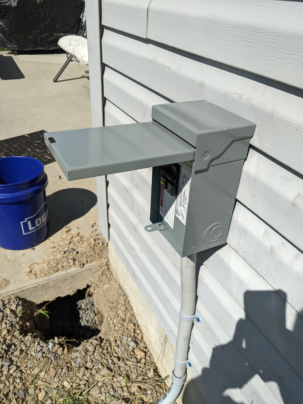 New outdoor disconnect box mounted on white siding