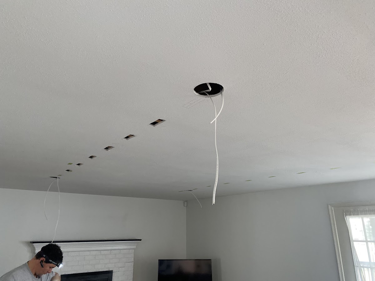 Recessed lighting installation in progress across a living room ceiling